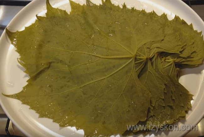 Из кастрюлю переправляем листья на тарелку, чтобы с них стекла лишняя вода.